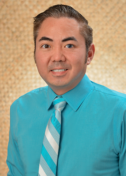 A professional headshot of a person wearing a turquoise dress shirt and striped tie, photographed against a woven-texture beige background.